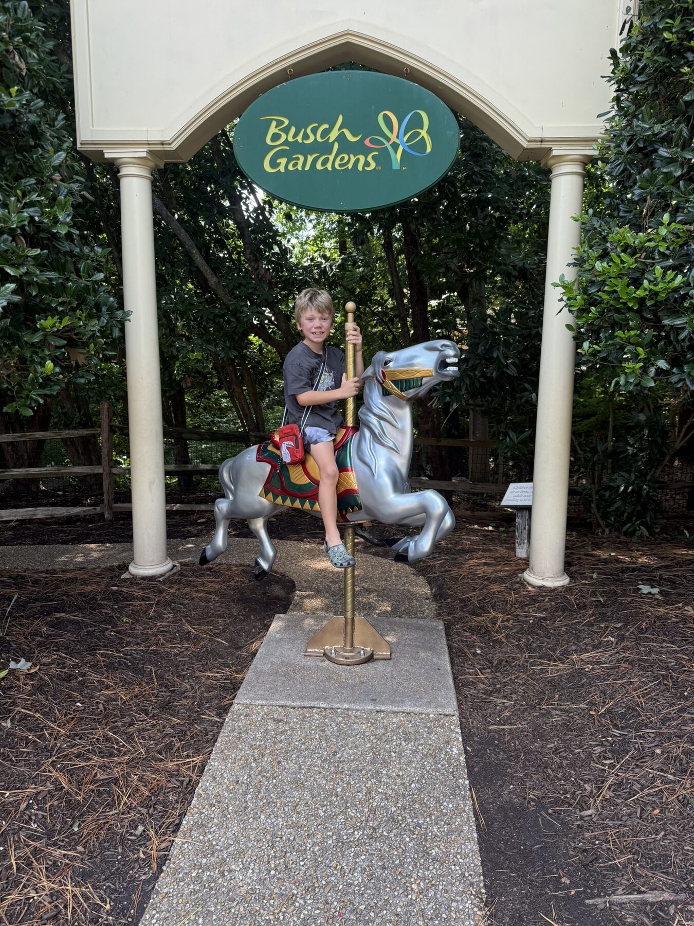Teddy on a carousel horse under the Busch Gardens sign