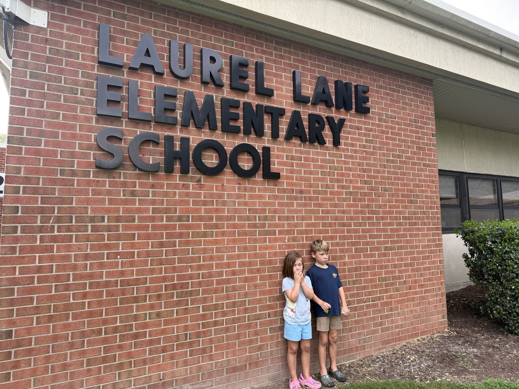 Teddy and his sister at the Laurel Lane Elementary School sign
